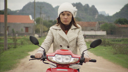 Hanh riding a motorbike (movie still)