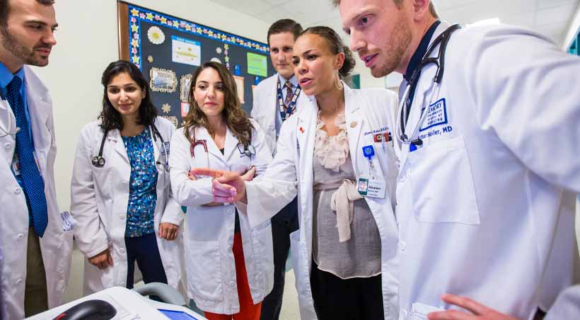 medical students stand in a circle learning in clinic