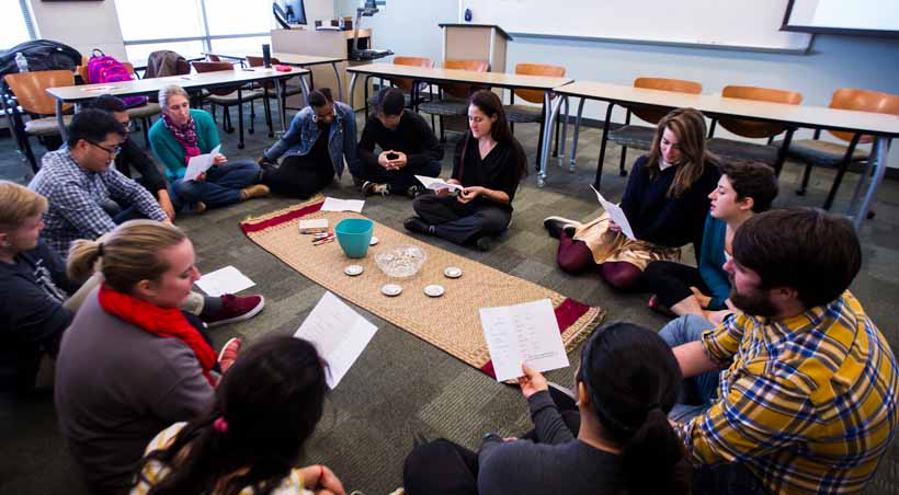 students sit around a table in class discussion