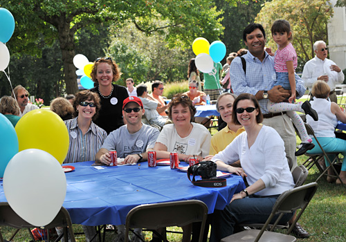 Homecoming attendees around a table on the quad