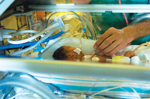 Small baby in hospital with adult caretaker