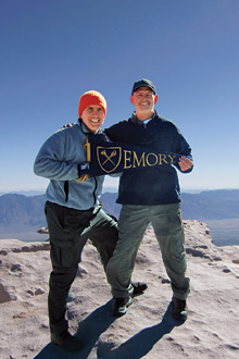 Two alumni on mountaintop with Emory flag