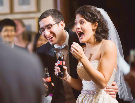 A happy bride with an expression of surprise on her face as she talks to wedding guests.