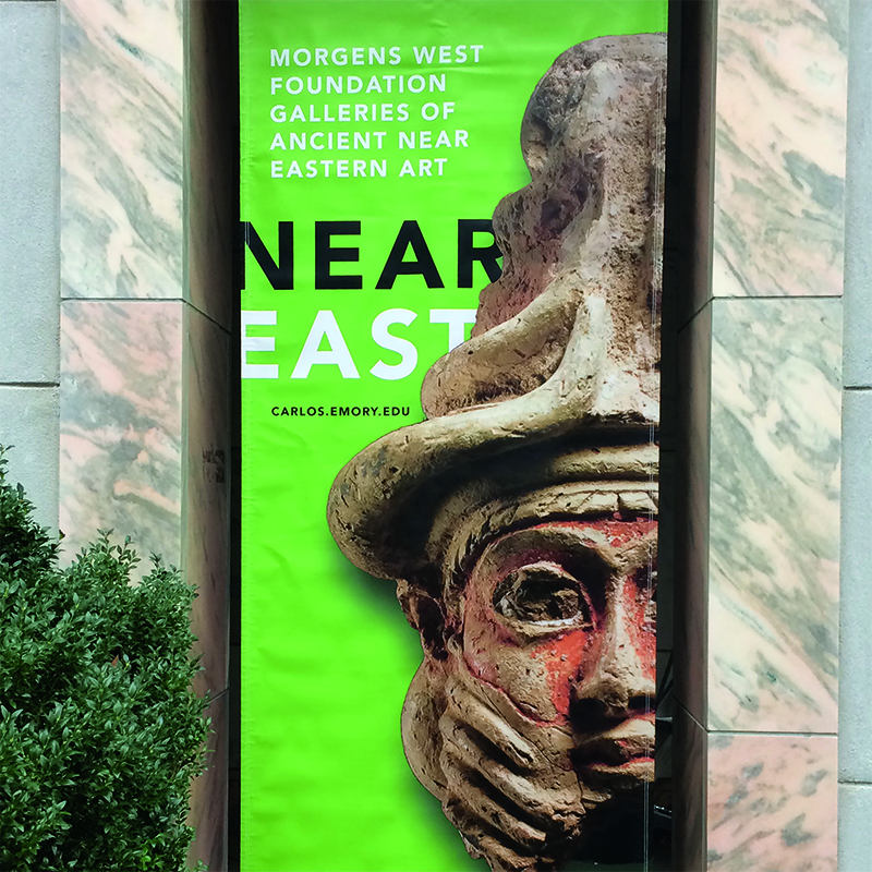 A green book cover with the title NEAR EAST with a photograph of a statue's head wearing a pointed, wrinkled hat.
