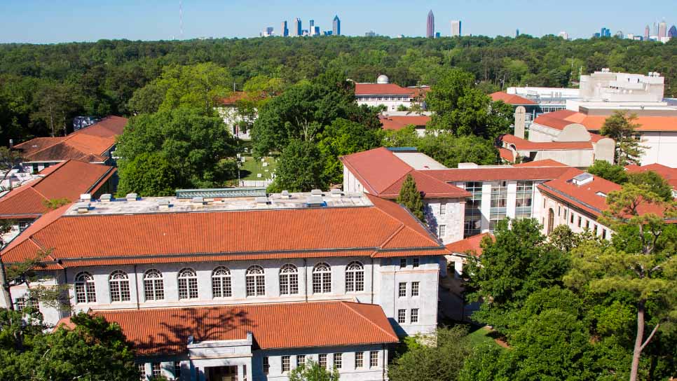 aerial view of Emory's campus with red-topped building and Atlanta in the distance