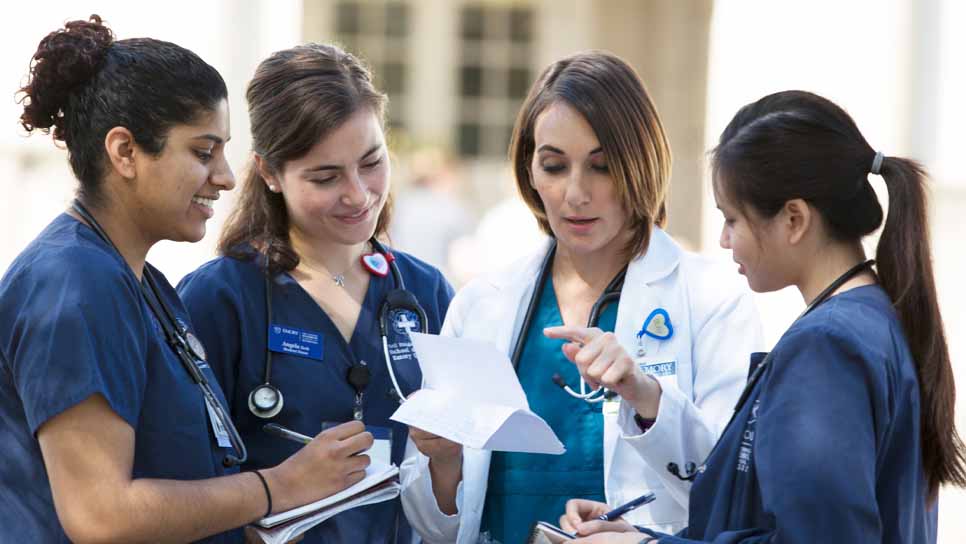 three nurses talking to a doctor in a clinical setting