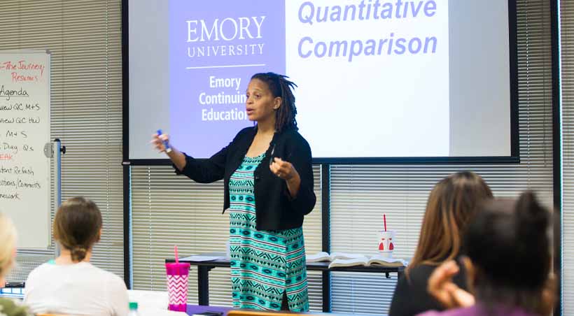 woman teaches class in front of powerpoint screen