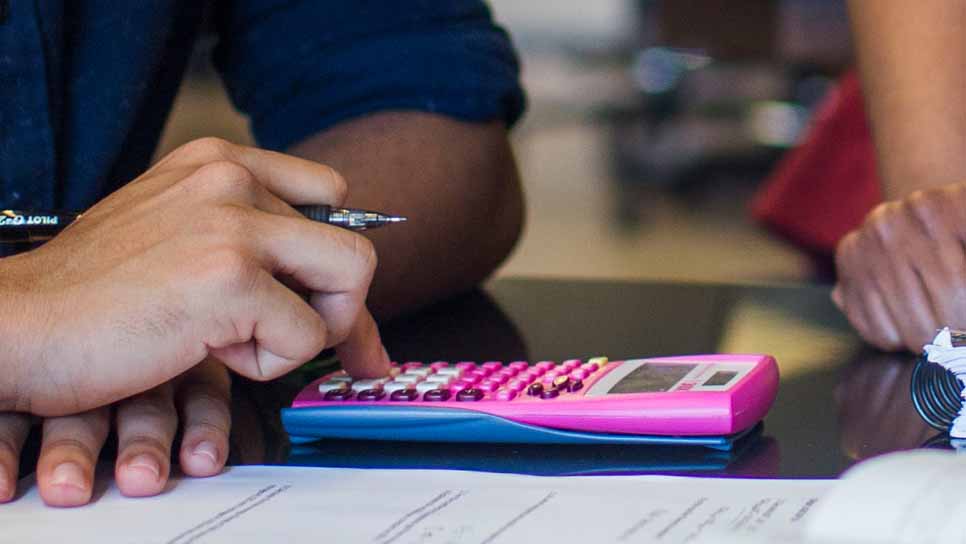 hand typing on calculator