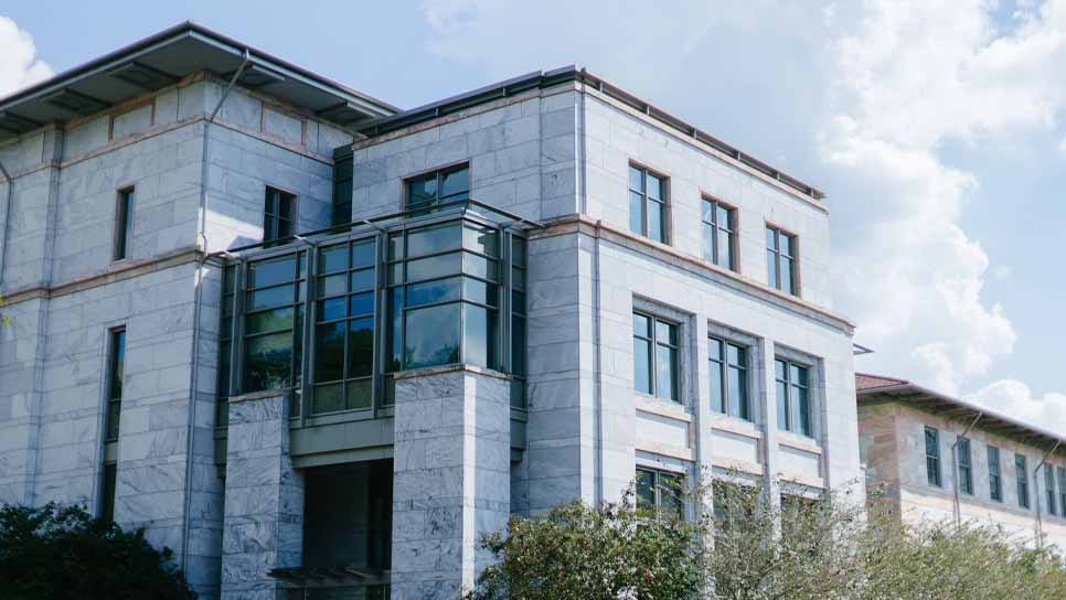 exterior view of medical school building with blue sky and white clouds