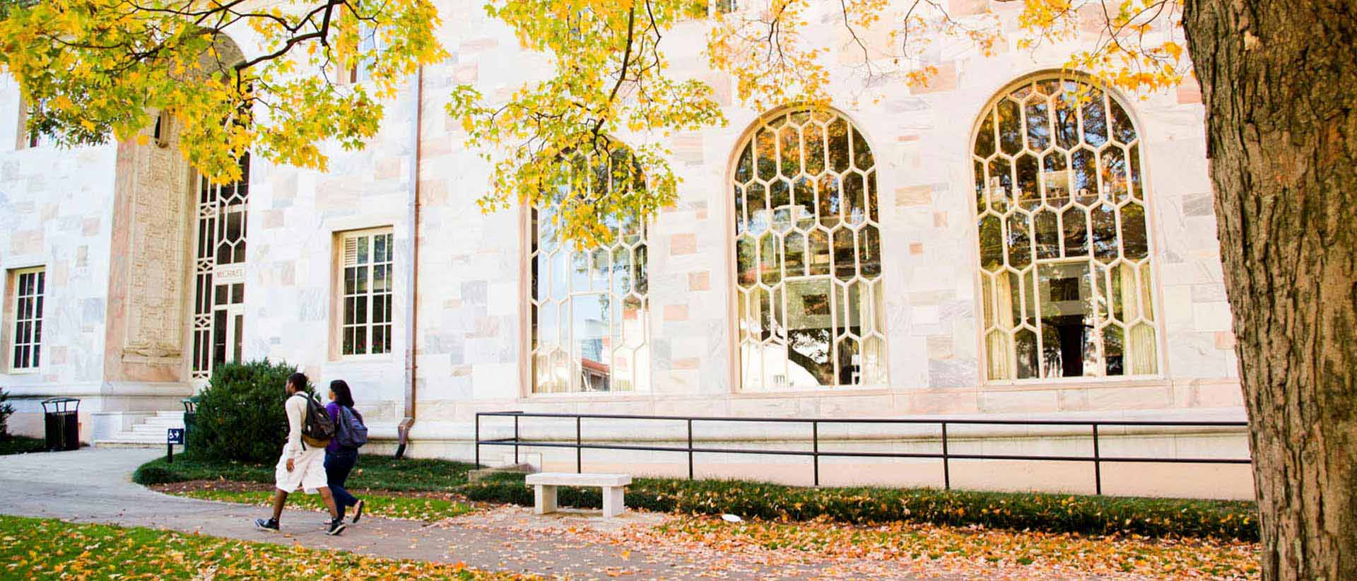 marble building on quad with yellow and green leaves in front of it