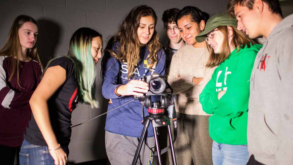 students in film class with camera