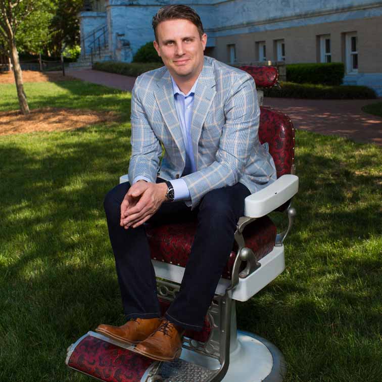 michael dubin sitting in barber chair on quad