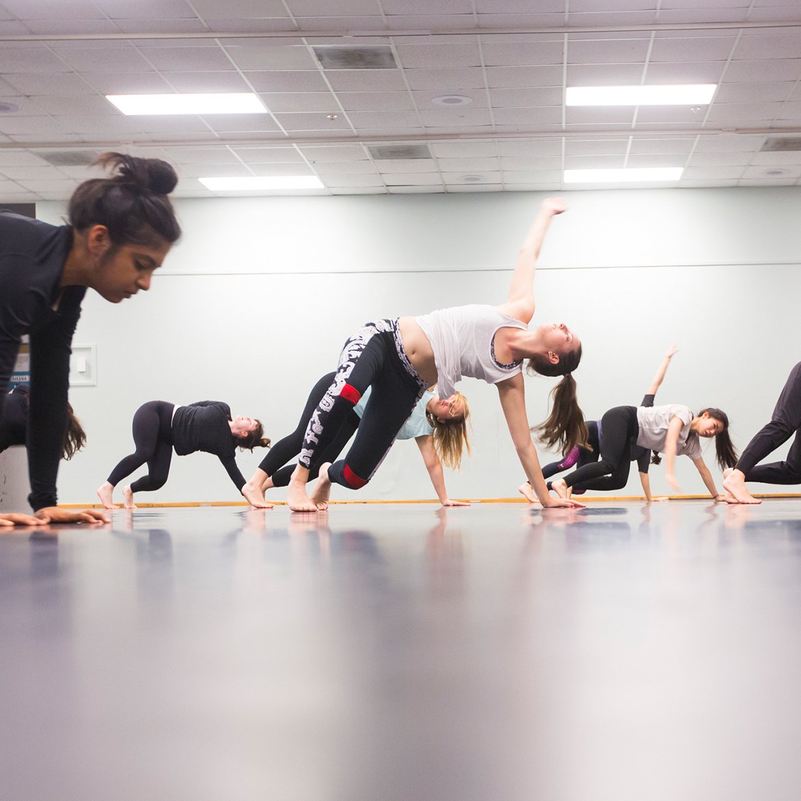 students practicing dance moves on the floor