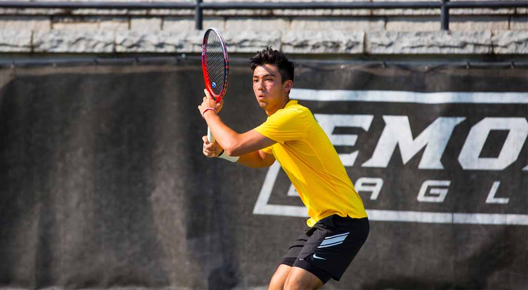 male student playing tennis