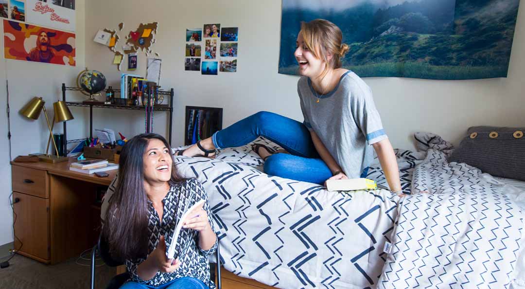 two female students talking in dorm room