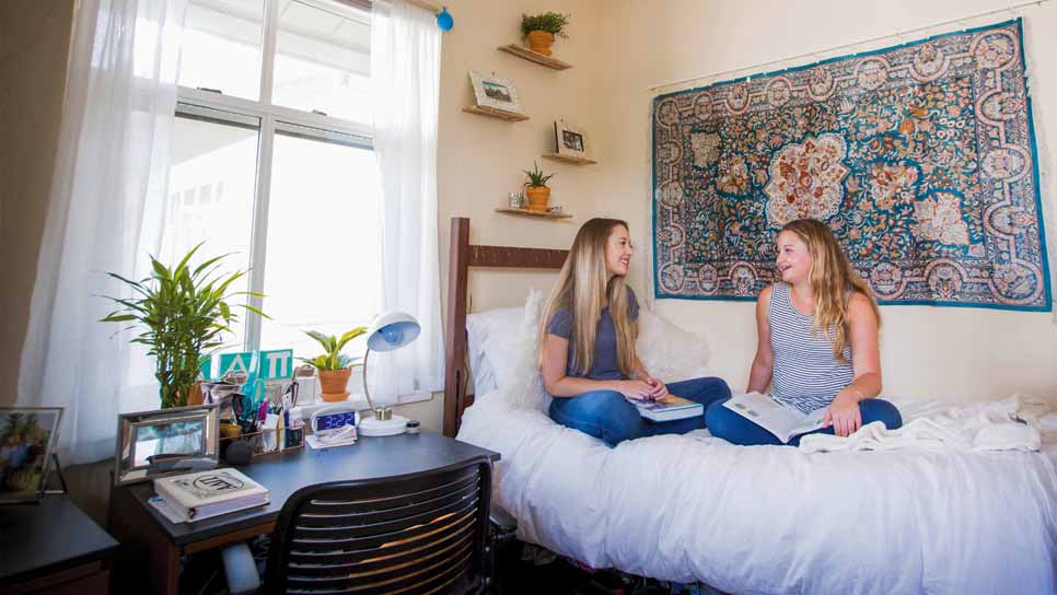 two students talk in dorm room