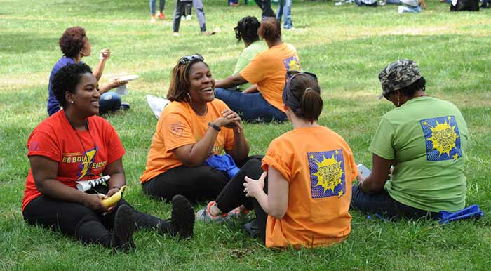 a group of people sitting on the grass during staff fest