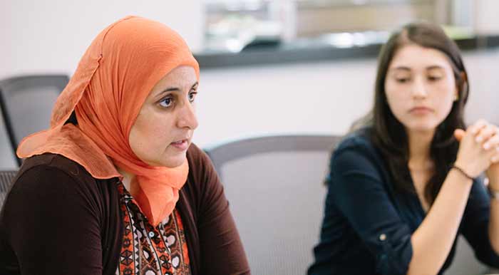 students sitting at a table participating in a class discussion