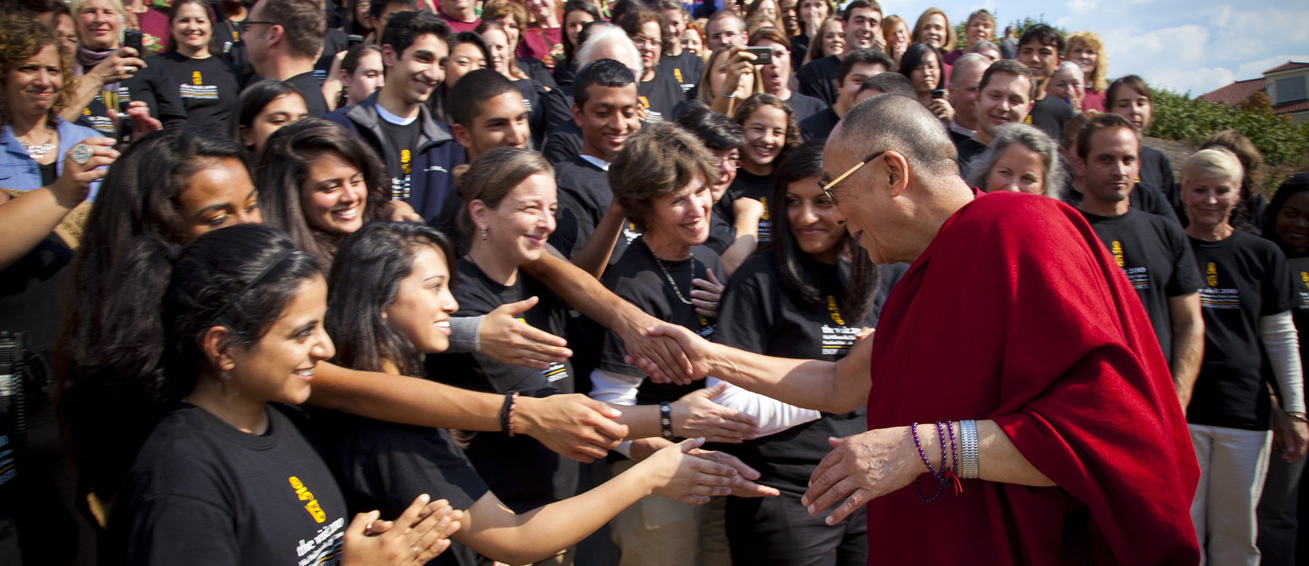 the dalai lama greets a crowd