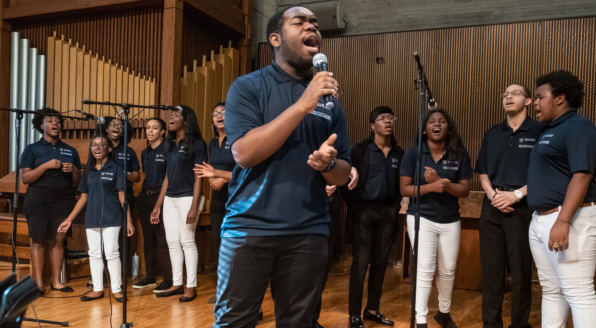 man singing with microphone surrounded by others