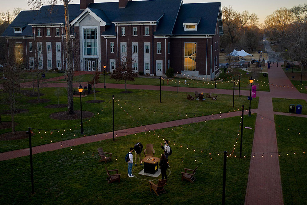 Students stand on the Oxford quad under string lights