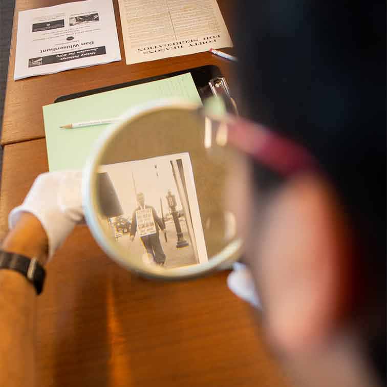 Researcher viewing a photo through a magnifying glass