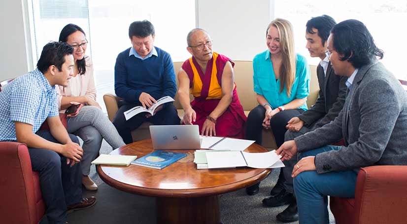 students sitting and discussing with a tibetan monk