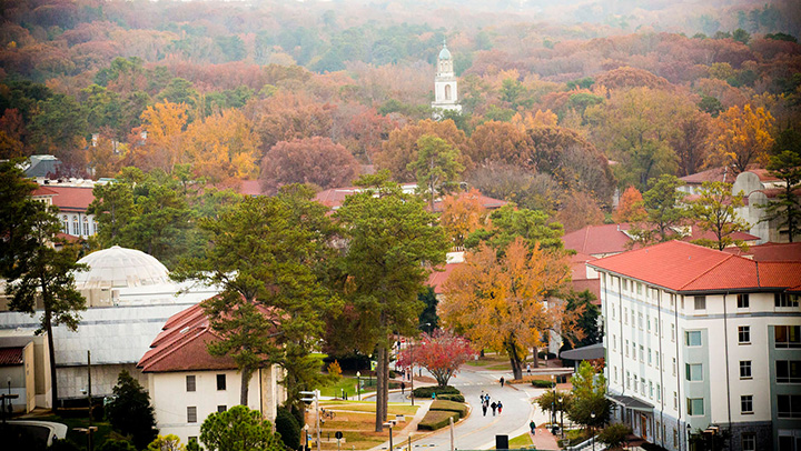 fall campus photo with multicolored leaves, red rooftops, and marble-clad buildings