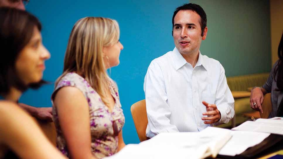 man talks to woman next to him at table