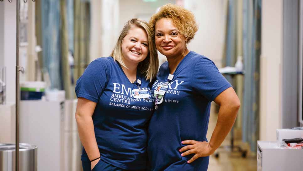 two nurses pose in hospital