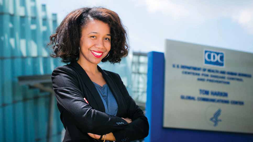 a woman poses in front of cdc sign