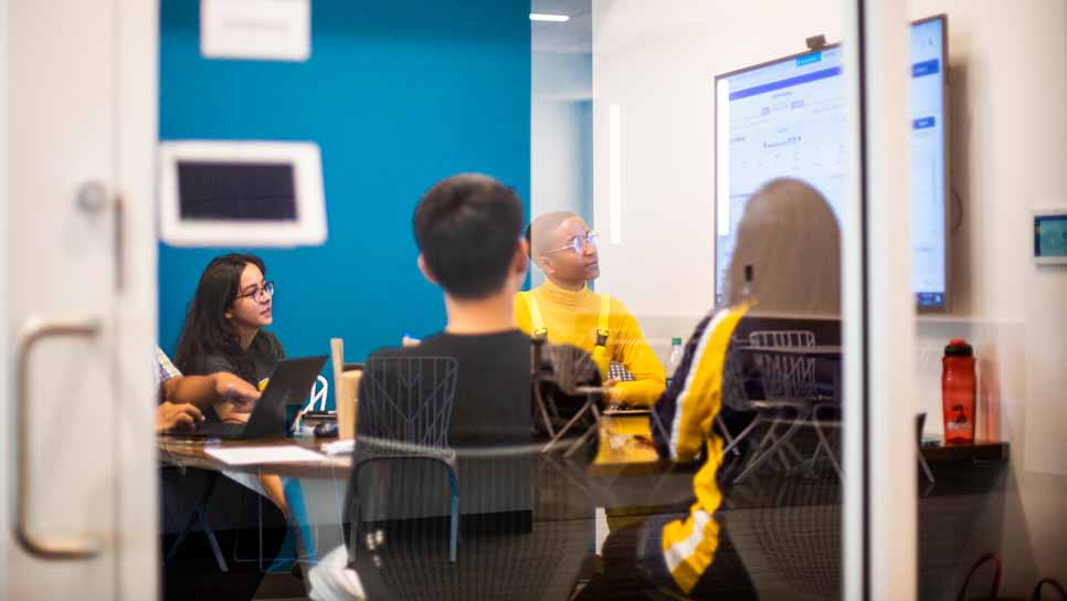 students meeting at a conference room table