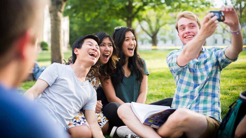 students sitting and laughing on quad