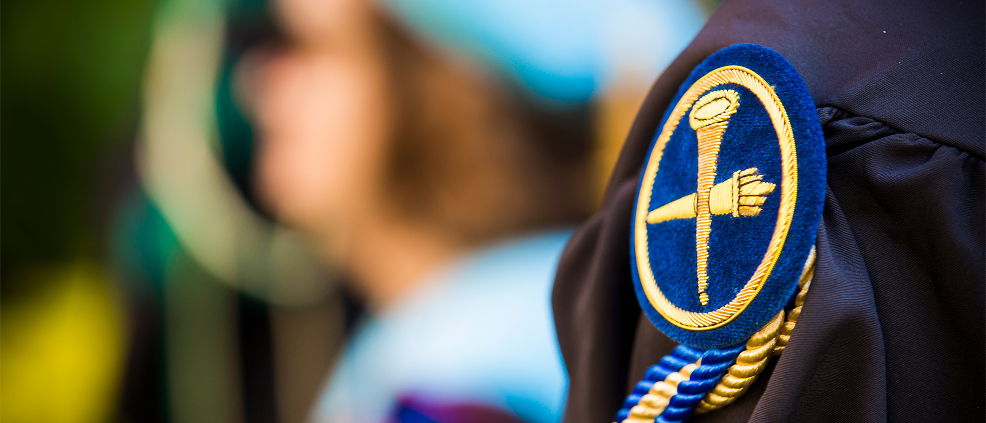 a close up image of the Emory shield emblem on a Commencement gown