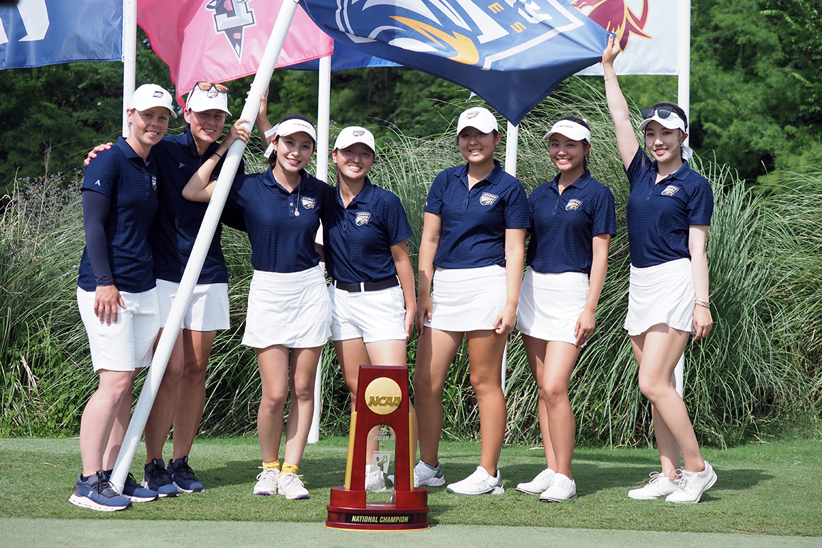 Emory women's golf team members pose with the NCAA championship trophy