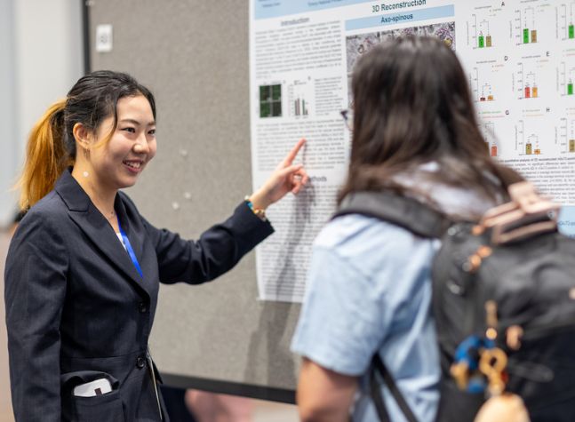 student in front of research poster 