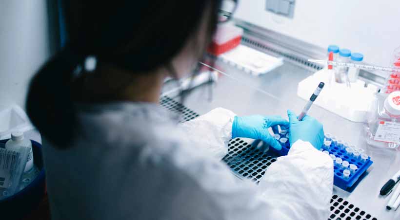 woman doing research in lab with gloves and white coat