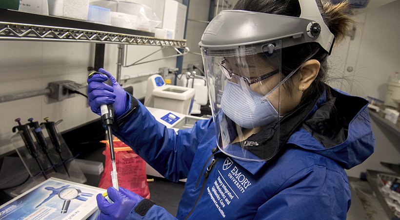 covid researcher working in a lab with mask and PPE