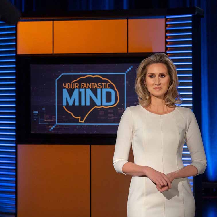 image of Your Fantastic Mind set with news anchor in white dress in foreground