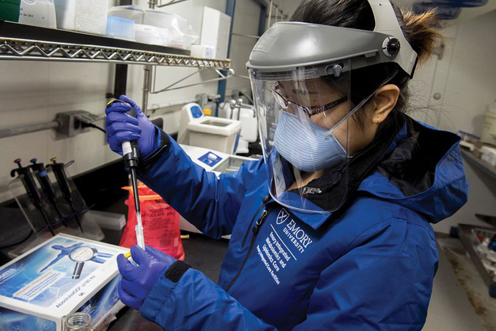 A photo of a woman researcher doing a COVID-19 test in a research lab