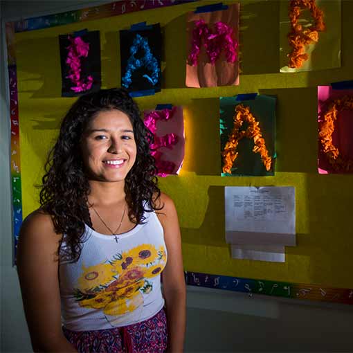 Emory student stands outside the classroom where she volunteered during the summer